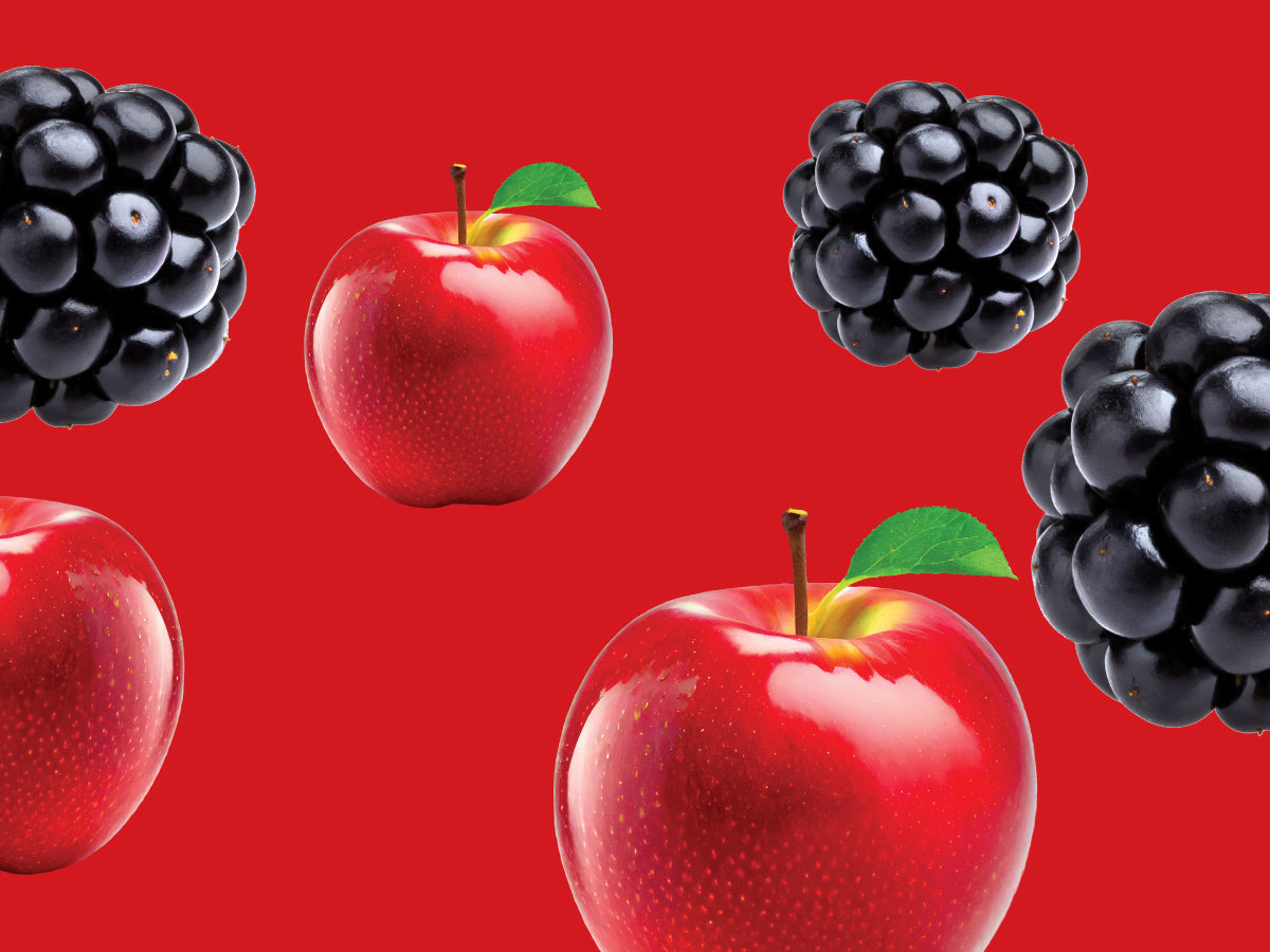 Red apples and blackberries on a red background
