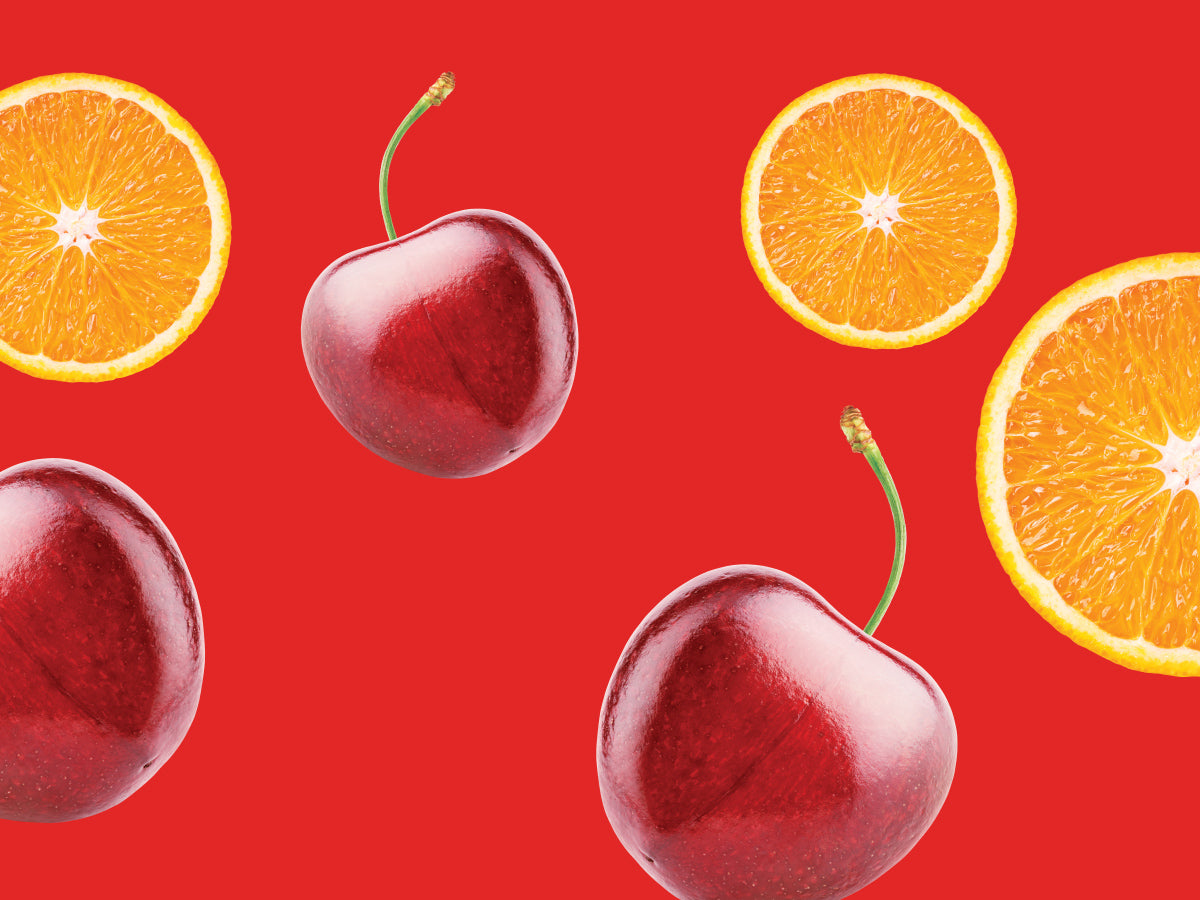 Cherries and orange slices on a red background