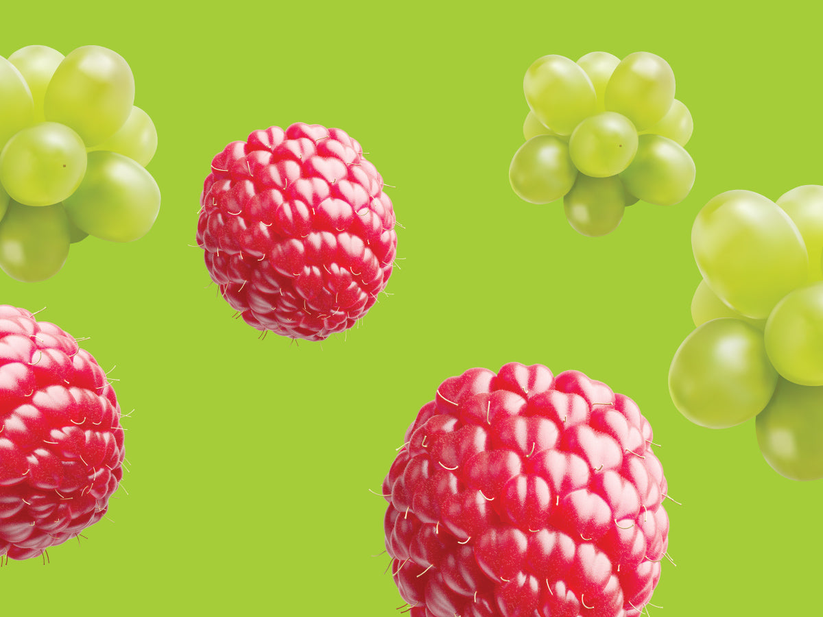 Raspberries and green grapes on a green background