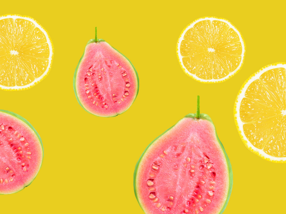 Pink guava halves and lemon slices on a yellow background