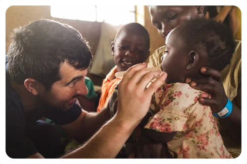 Man feeding a child in a warm, indoor setting